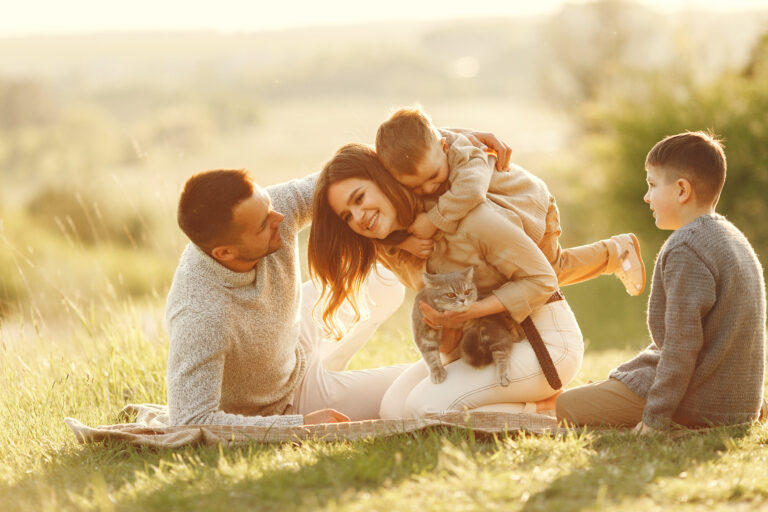 Family with cute little child. Father in a gray sweater. Sunset background. Little kitty;