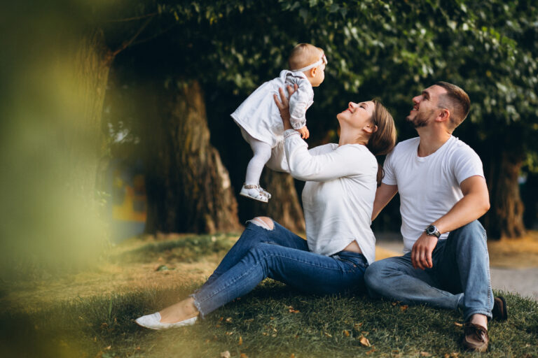Young family with their small daughter in autumn park